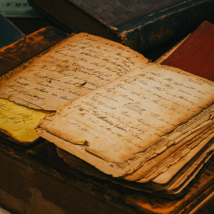 Home Old paper with cursive writing on a vintage desk, capturing a timeless historical essence.